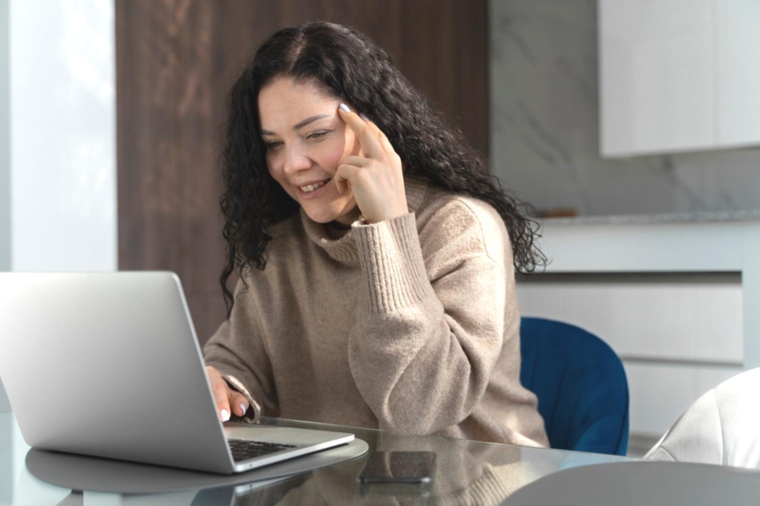 Gemütlicher Arbeitsplatz mit offenem Laptop und Kaffeetasse